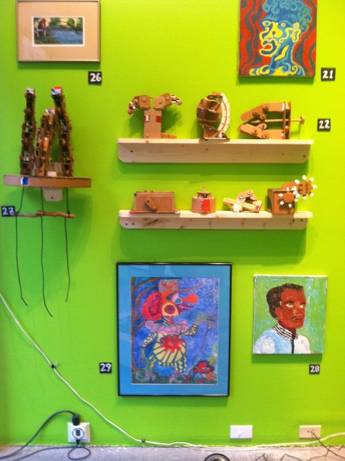At top, robotic hand and other cardboard sculptures by Doug Hill.  At bottom, paintings by Steve Smith.
