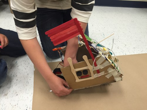 As student setting a robotic vehicle to motion.