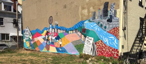 The completed mural spans the length of an apartment building.