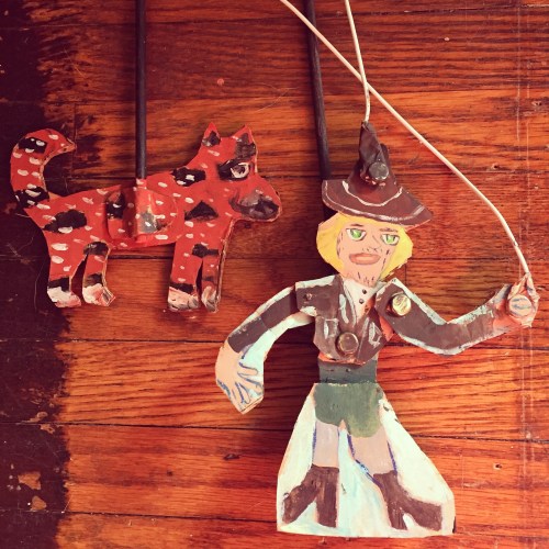 In Part 1, a toy theater scene features miniatures of main characters. 