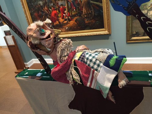 Van Winkle puppet snoozes next to a tree with his crazy quilt covering in Part 1. 